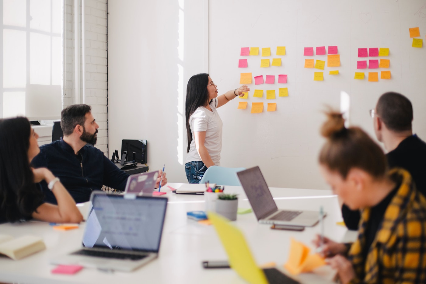 Marketing team planning a strategy around a whiteboard